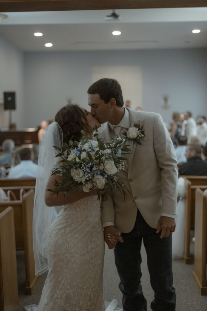 Callie and Matt stop for a quick kiss as they walk back up the aisle