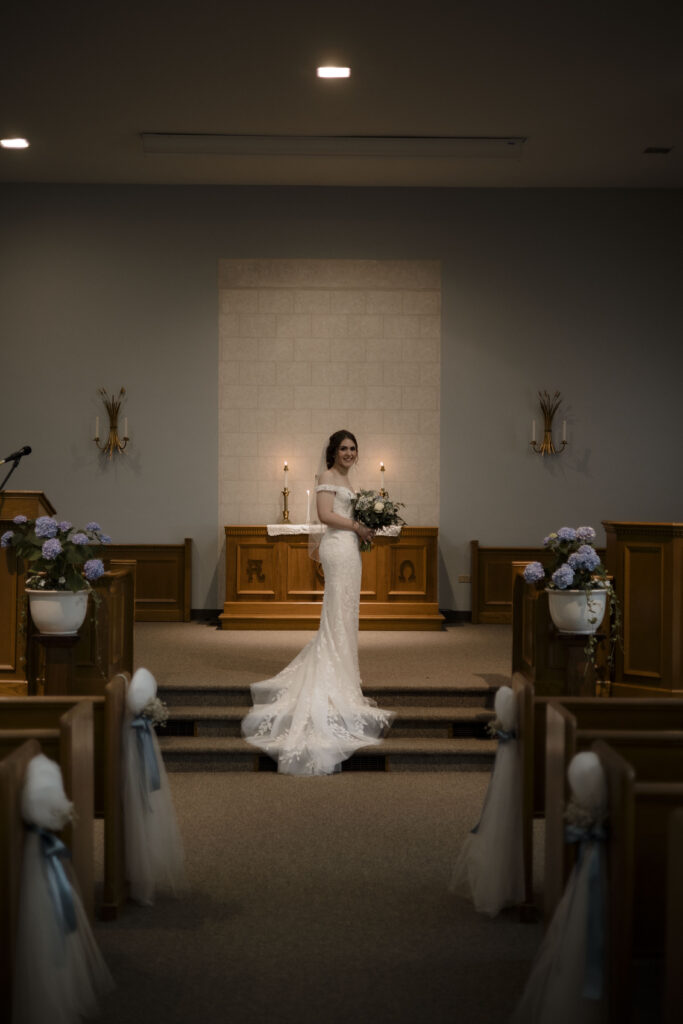 Callie poses in front of the church in her wedding gown