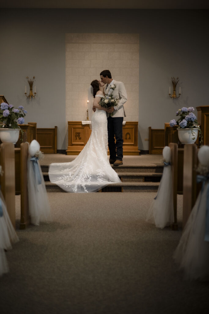 Callie and Matt share a kiss post ceremony at the front of the church