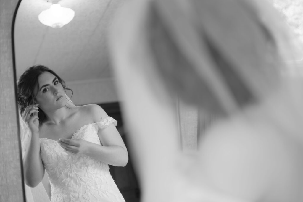 Callie finishes putting on her jewelry in the mirror