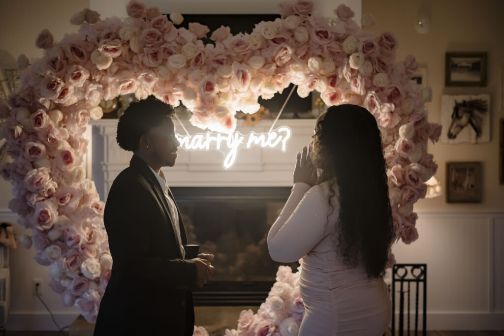 Kiki stands hands clasped in front of her face as she waits for Chris to propose