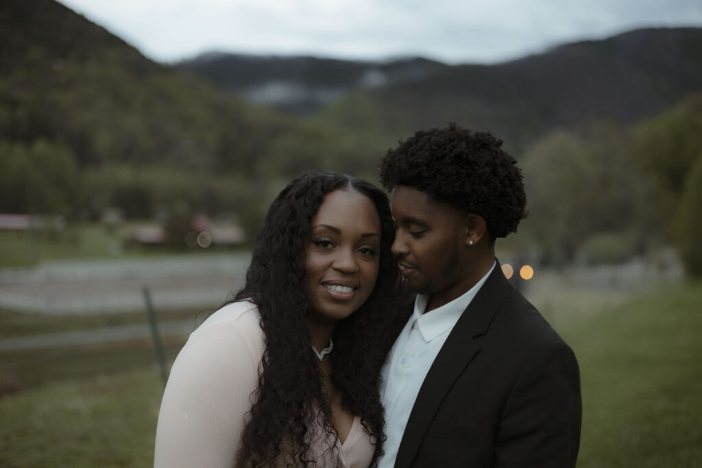 Chris and Kiki embrace in front of the smoky mountains